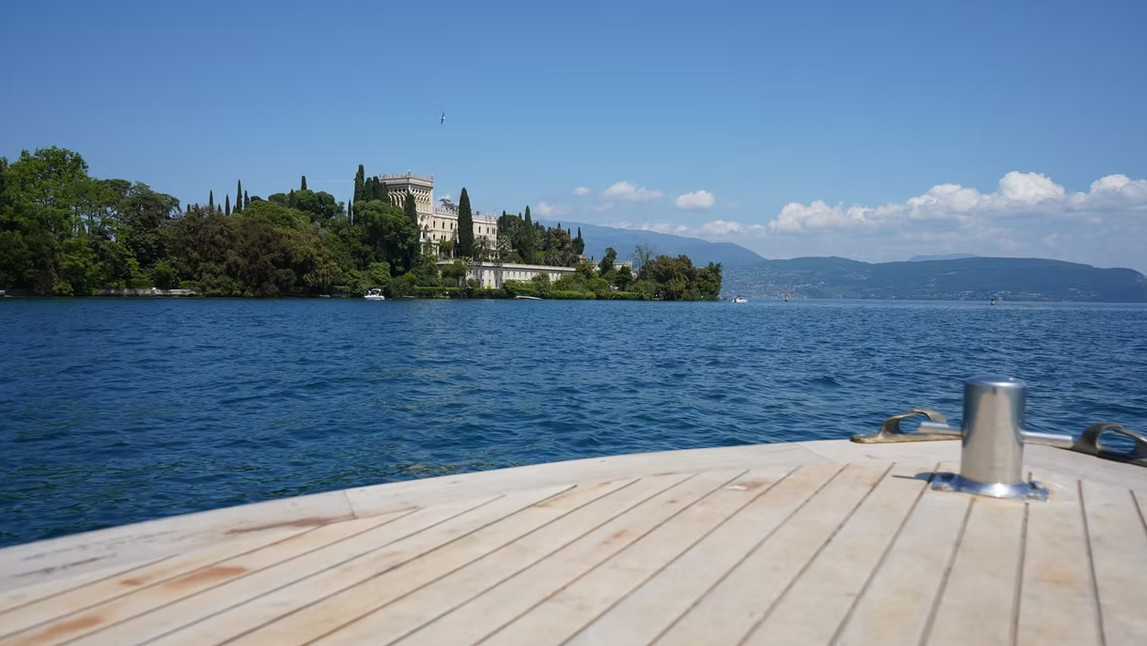 View of Isola del Garda and its historic villa from a boat on Lake Garda, Italy