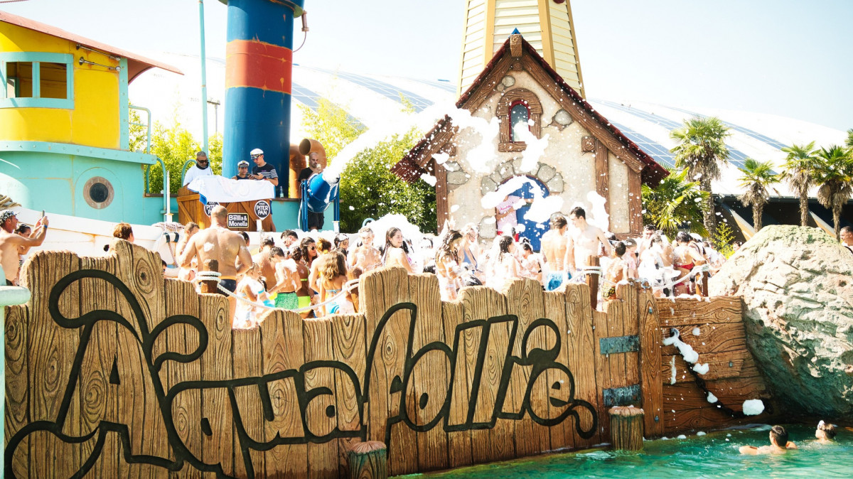 Animation team playing music on a pirate-themed boat during a foam party with people dancing, Aquafollie event