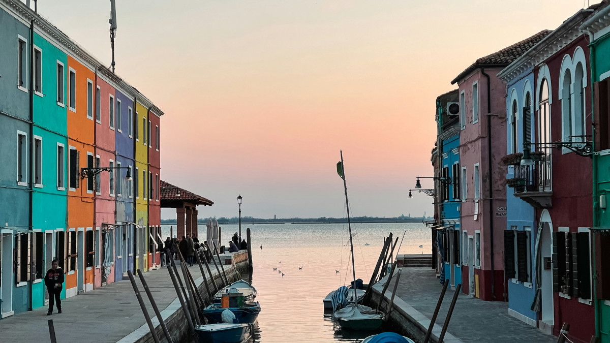 Sunset over the Venetian lagoon with colorful houses and small boats in Burano, Venice