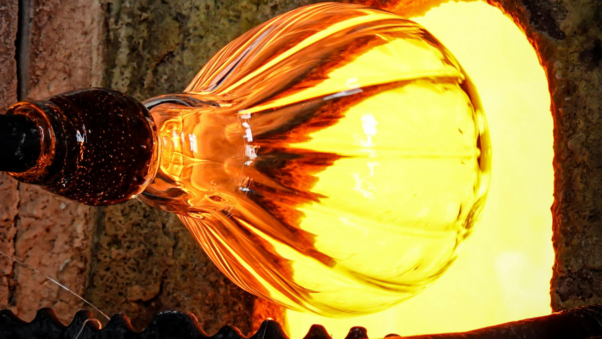 Authentic glass blowing demonstration in Venice; artisan shaping glowing hot glass at a furnace during a Murano island tour