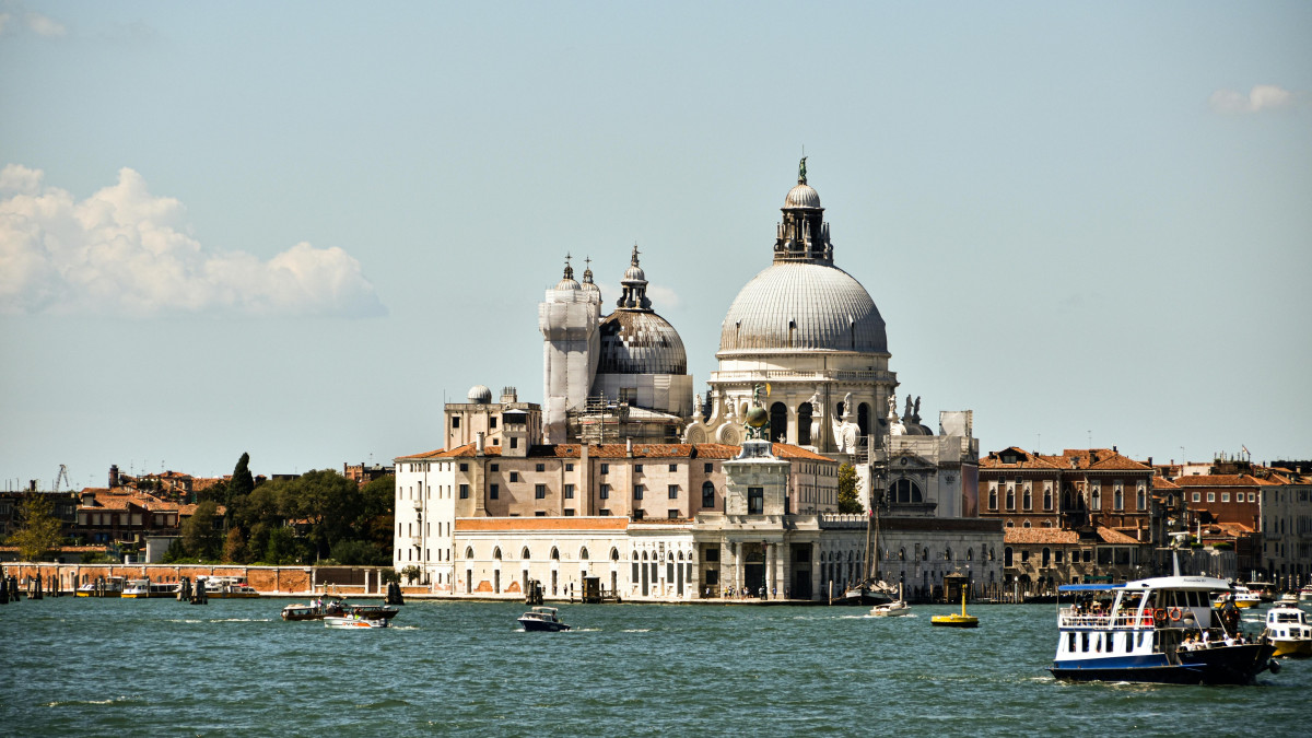 Panoramic view of Santa Maria della Salute Basilica in Venice across the Grand Canal with vaporettos and boats on the water
