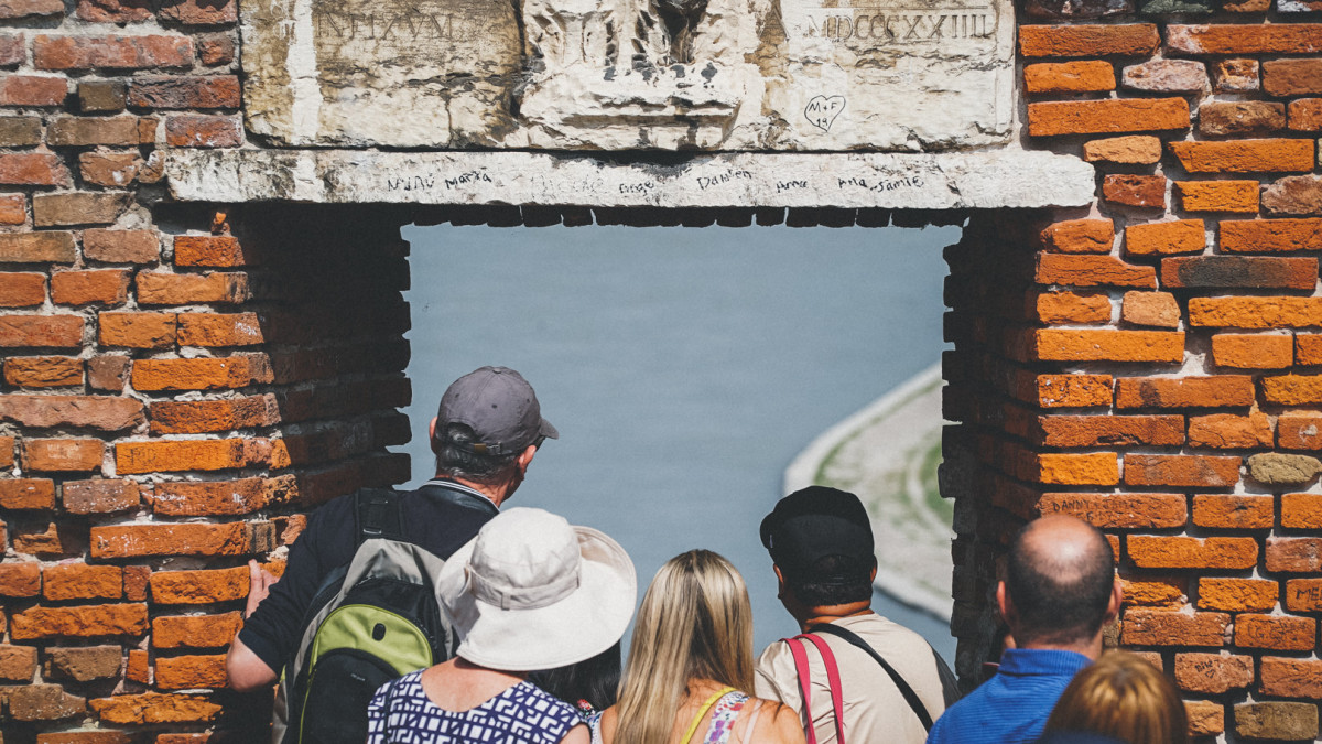 Visitors enjoying the view from Verona’s red brick bridge over the river