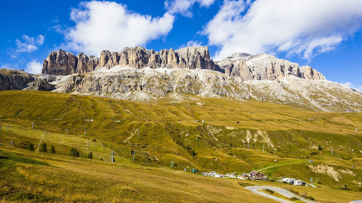 Pordoi Pass with green grass and the dolomites mountain in the background