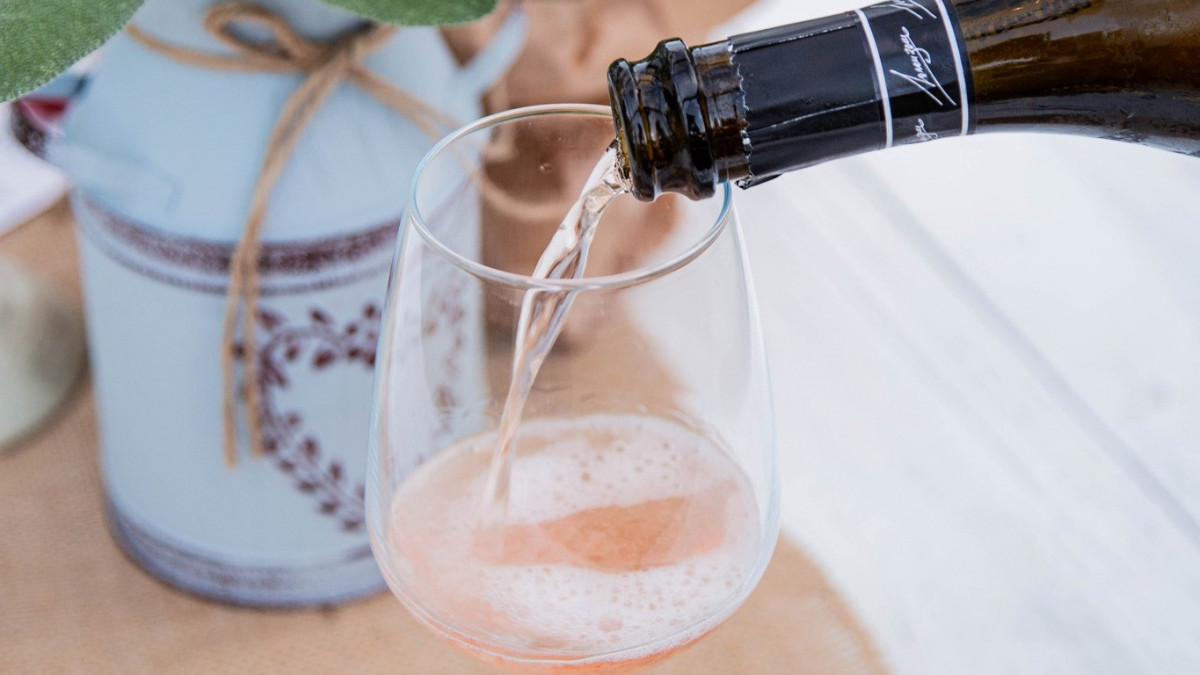 Expertly pouring a glass of local sparkling wine during an outdoor farm tasting at Azienda Agricola Valleri.