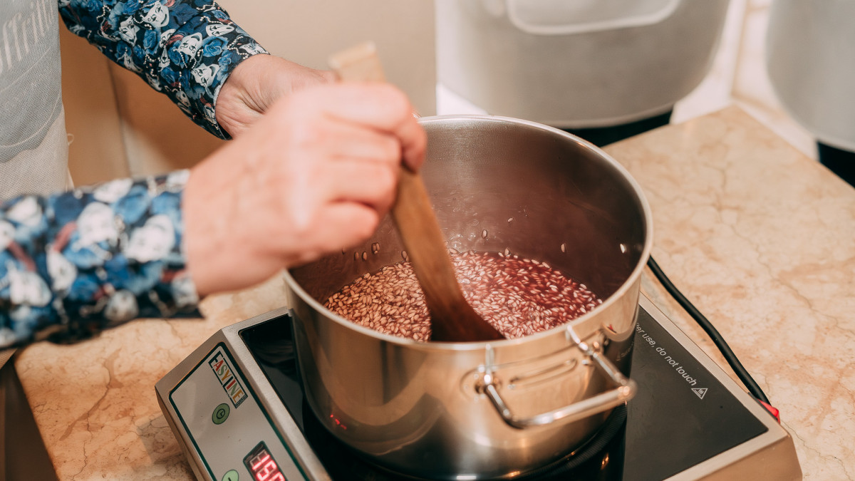 A participant stirring creamy risotto in the pan as it slowly cooks to perfection.