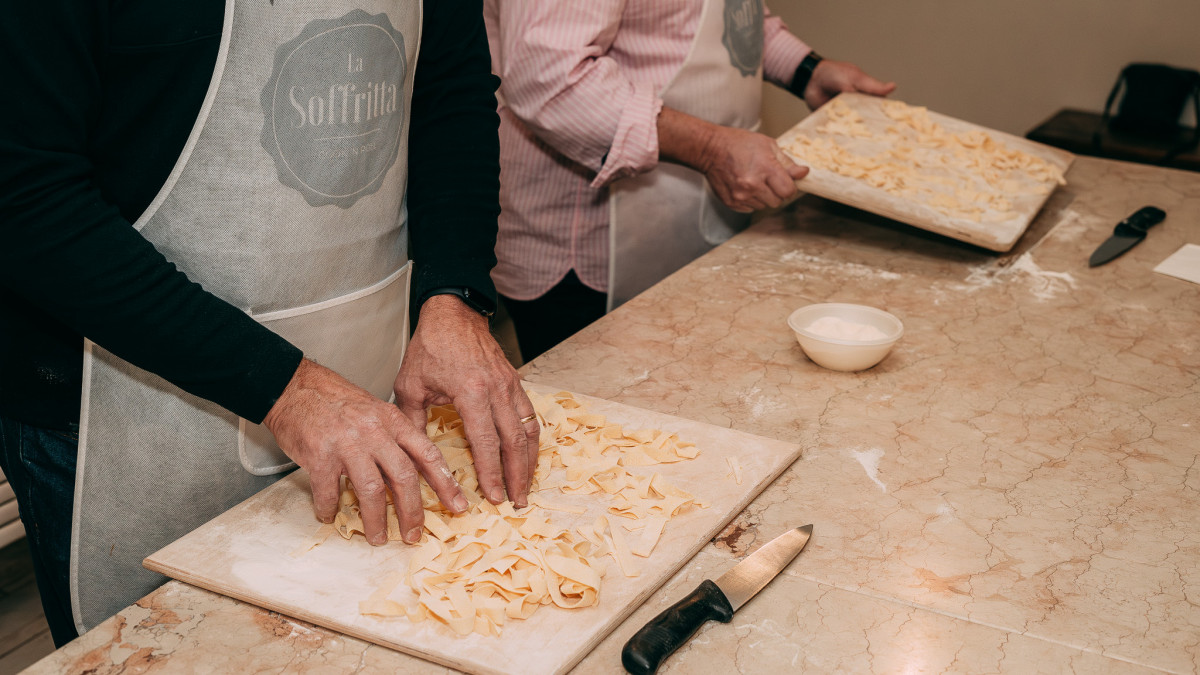 A participant carefully kneading fresh pasta dough during the cooking class.