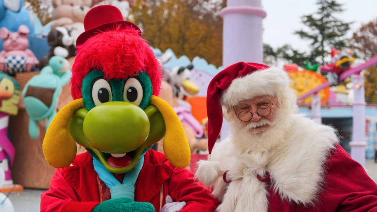 Prezzemolo mascot and Santa Claus smiling together during the Gardaland Magic Winter Christmas event at Gardaland Park, Italy.