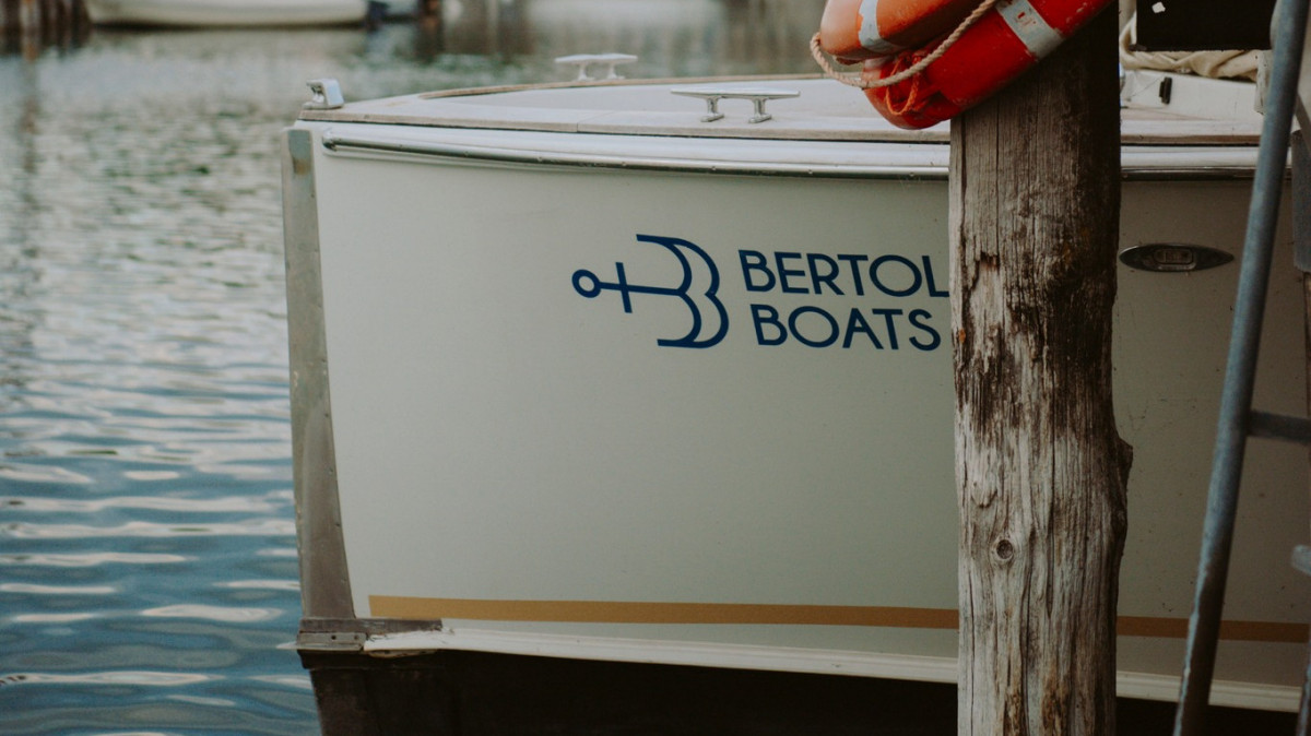 Close-up of the official Bertoldi Boats logo on a luxury motorboat moored at Lake Garda, Italy.