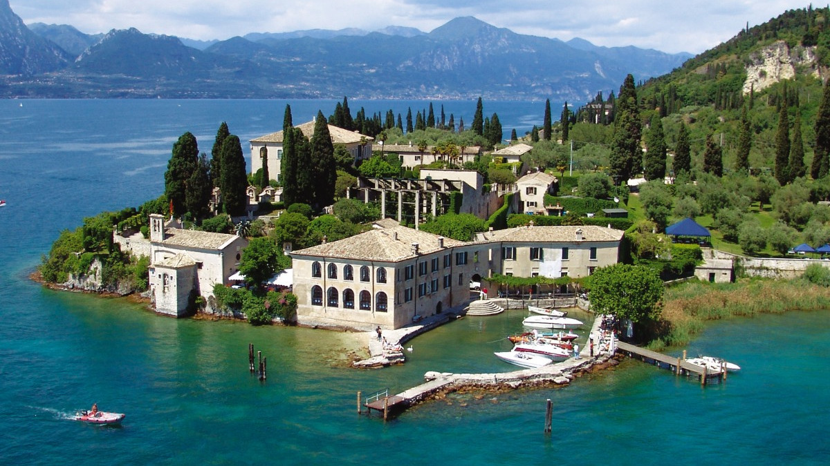 Aerial view of Punta San Vigilio on Lake Garda during a Bertoldi Boats island tour, featuring the historic harbor and Locanda San Vigilio