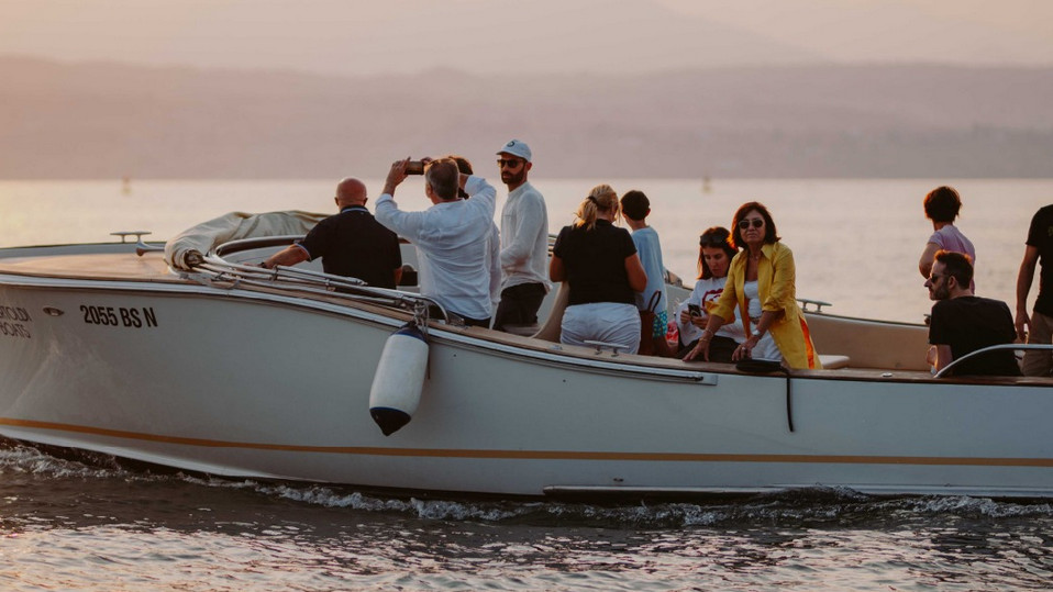 Group of tourists enjoying a boat tour on Lake Garda aboard a classic Bertoldi Boats motorboat.
