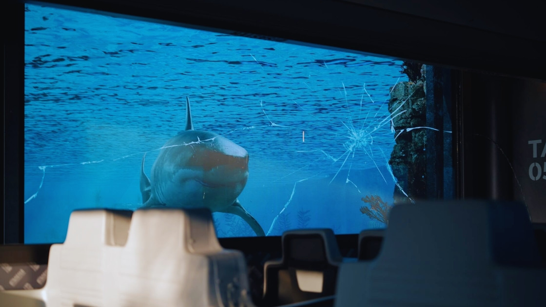 Movieland attraction "Disaster: The Blockbuster Tour", facing a digital screen where a CGI shark appears to break through the glass.