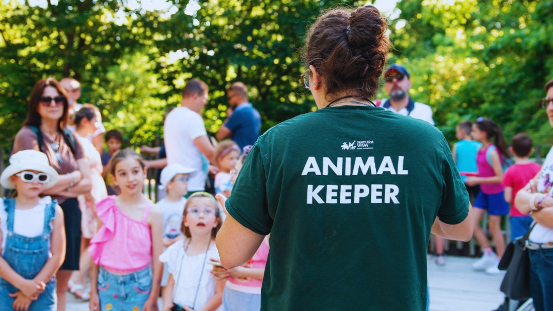 An animal keeper talking to families and children during an educational meeting at Parco Natura Viva.