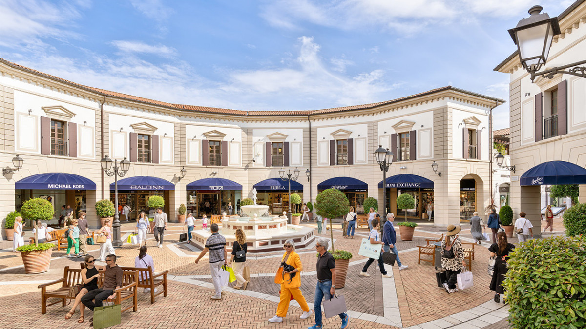 Luxury fashion stores including Michael Kors, Furla, and Armani Exchange at Noventa di Piave Designer Outlet village.