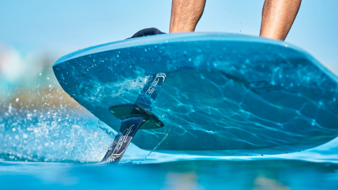 Close-up view of an electric eFoil mast and wing cutting through Lake Garda water