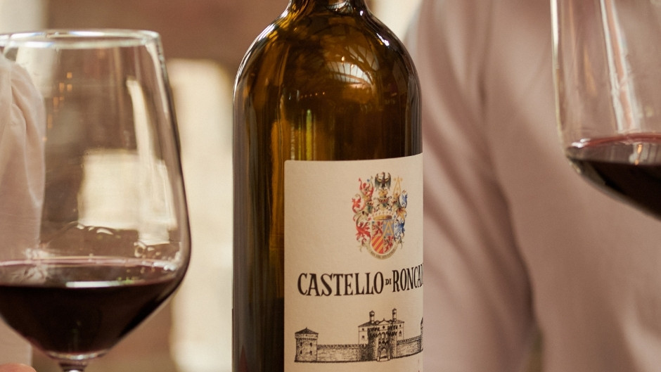 Close-up of a Castello di Roncade Villa Giustinian wine bottle on a table with glasses of red wine during a tasting session