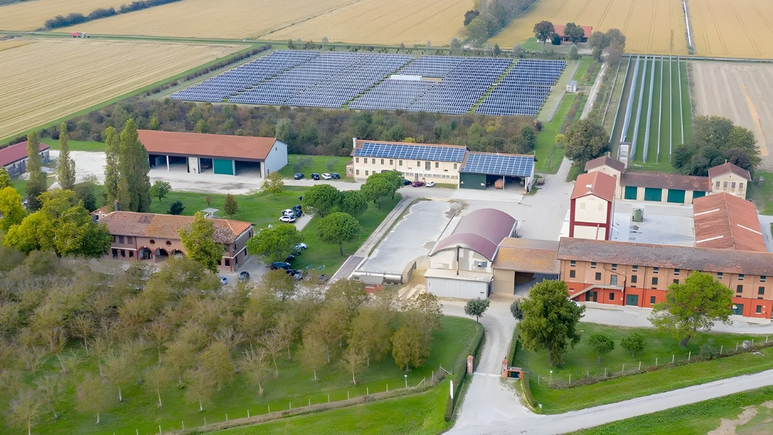 Aerial view of Azienda Agricola La Fagiana, showing sustainable farm buildings and a large solar panel array in the Italian countryside.